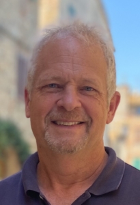 Smiling middle-aged man outdoors on a sunny day.